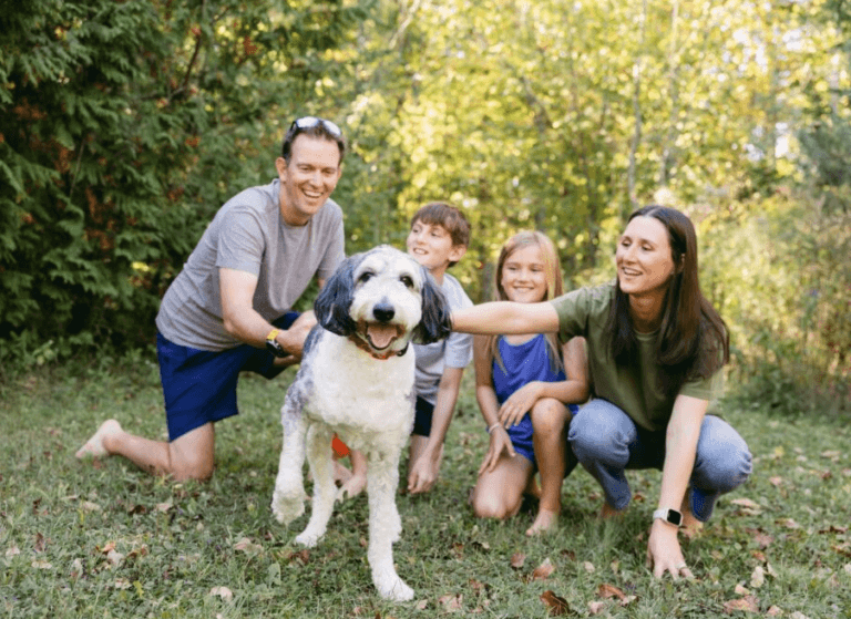 a happy family pets their dog